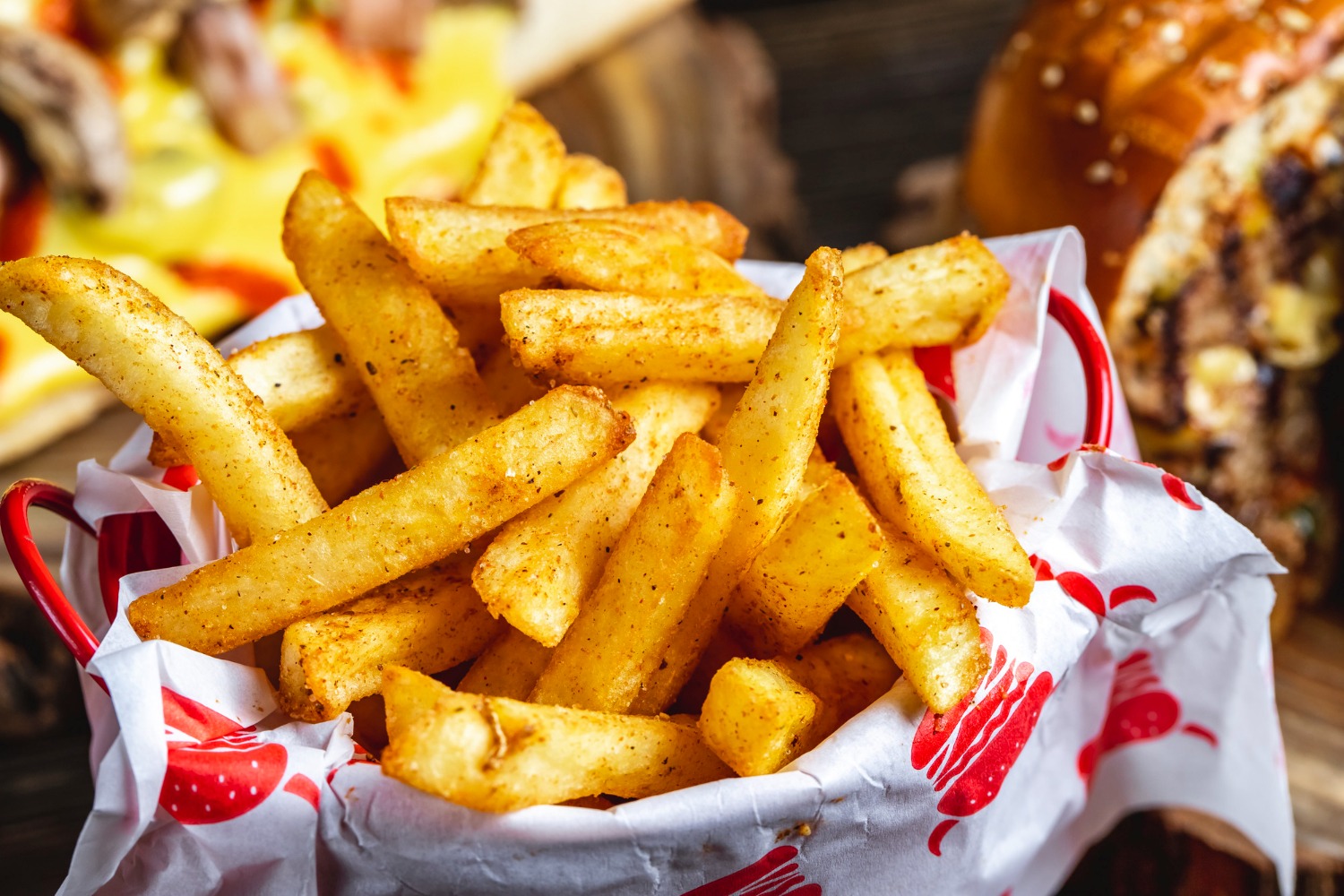 Knusprige Pommes frites mit goldener Kruste, serviert mit Ketchup und Mayo auf einem weißen Teller. Perfekt für jeden Pommes-Liebhaber!